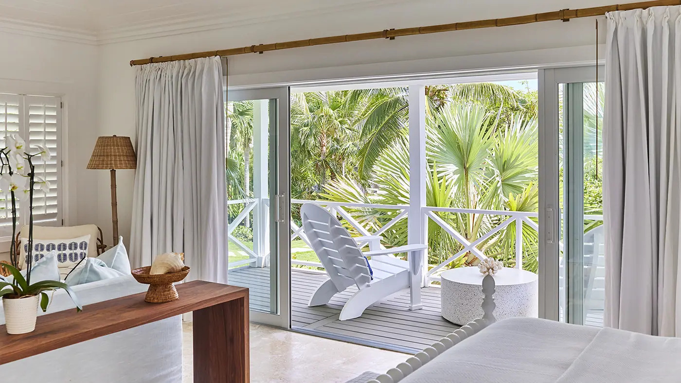 Garden-view Cottage veranda with Adirondack chairs at The Potlatch Club, Eleuthera